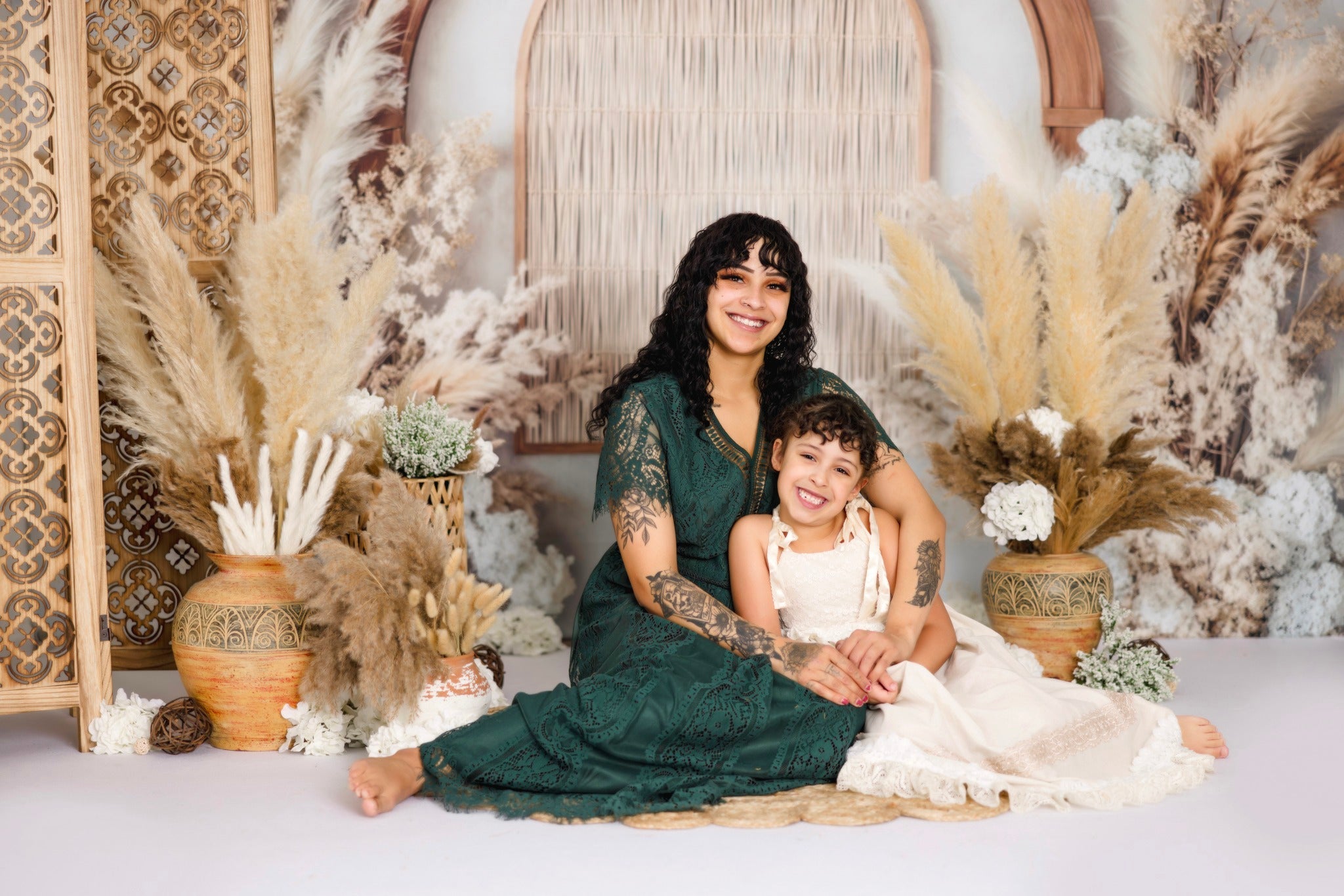 family with a dog sitting on the floor in front of a boho backdrop