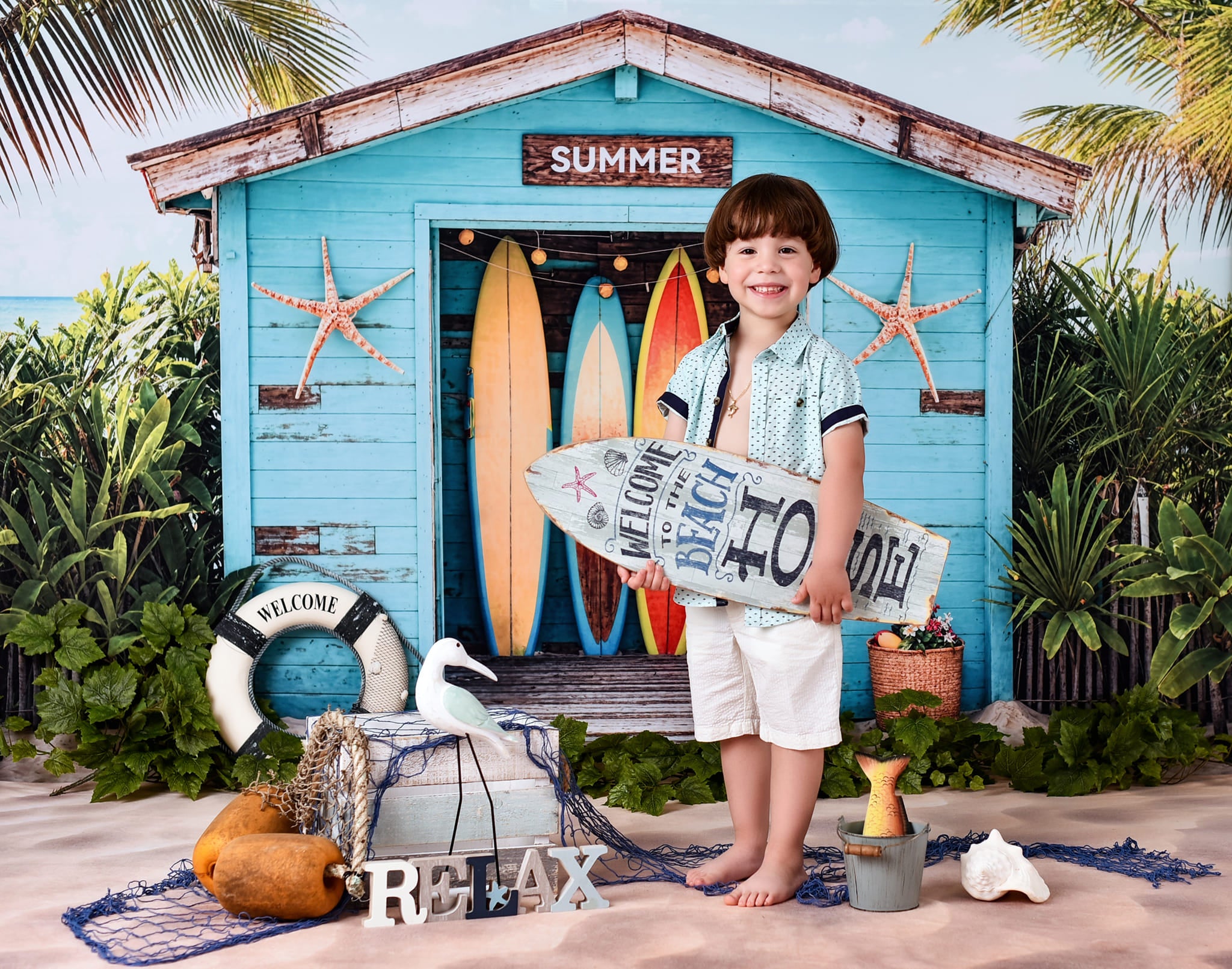 A boy standing at the seaside surfboard backdrop 