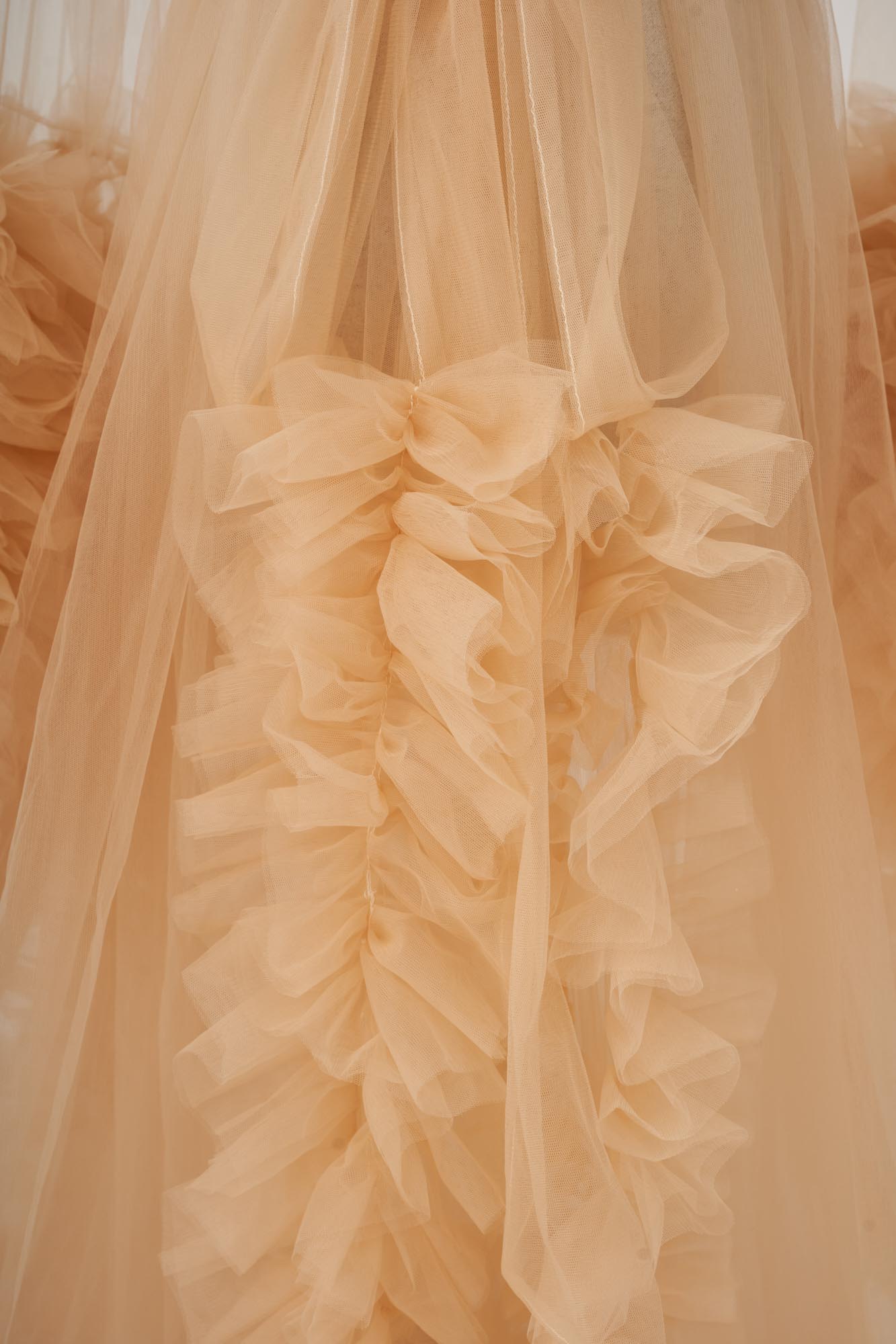 Detail shot of yellow flared sleeve tulle ruffle maternity dress hemline